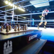 Chess board in foreground of a boxing match