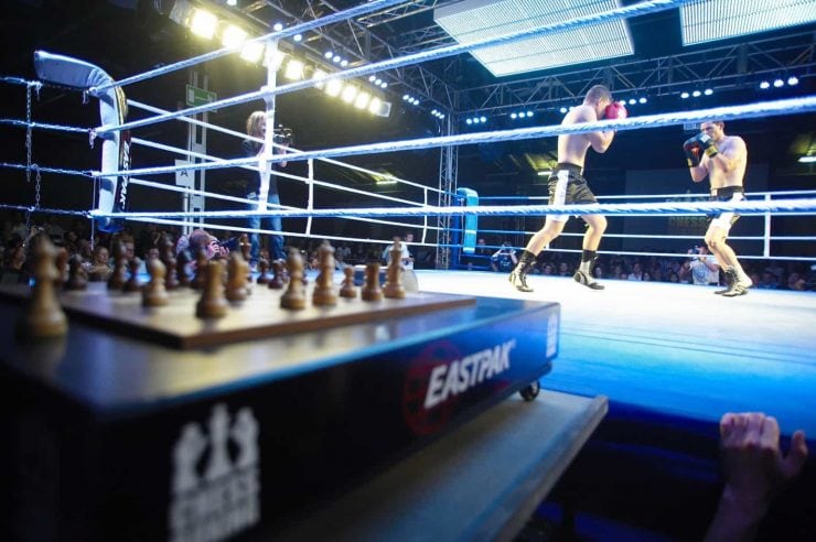 Chess board in foreground of a boxing match