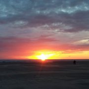 Picture of a sunset on Ainsdale beach. The sky is glowing below deep blue clouds