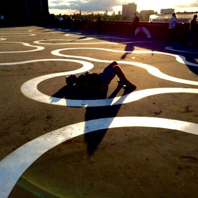 An image of a man lying on the floor as the sun creates a silhouette of his figure