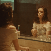 A girl staring at her reflection in the mirror