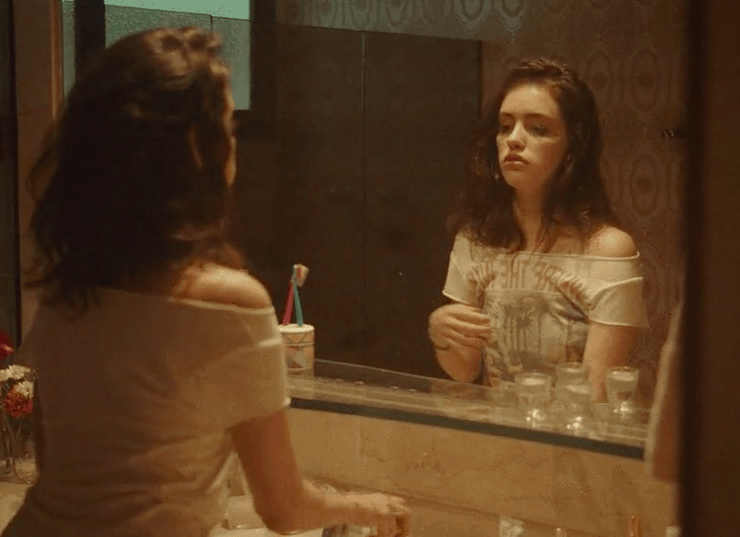 A girl staring at her reflection in the mirror