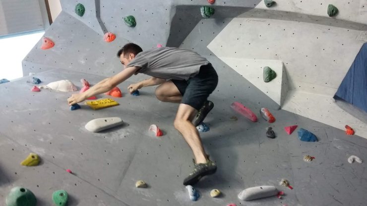 An man scales an indoor climbing wall