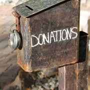 A rough rusty old donations box padlocked up.
