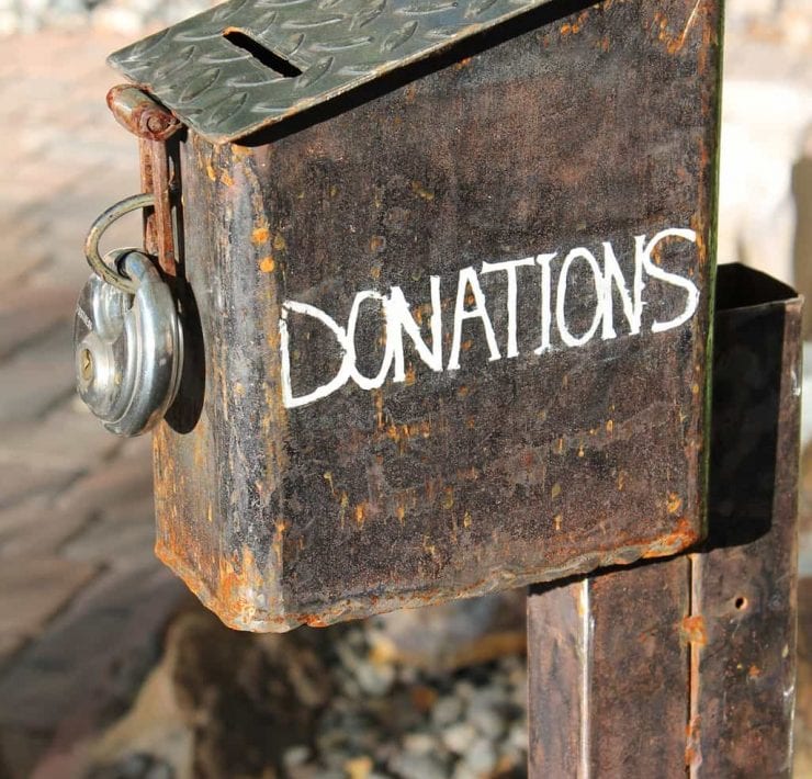 A rough rusty old donations box padlocked up.