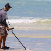 A man scouring the beach with a metal detector