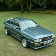 A green Audi Quattro sits on a patch of grass