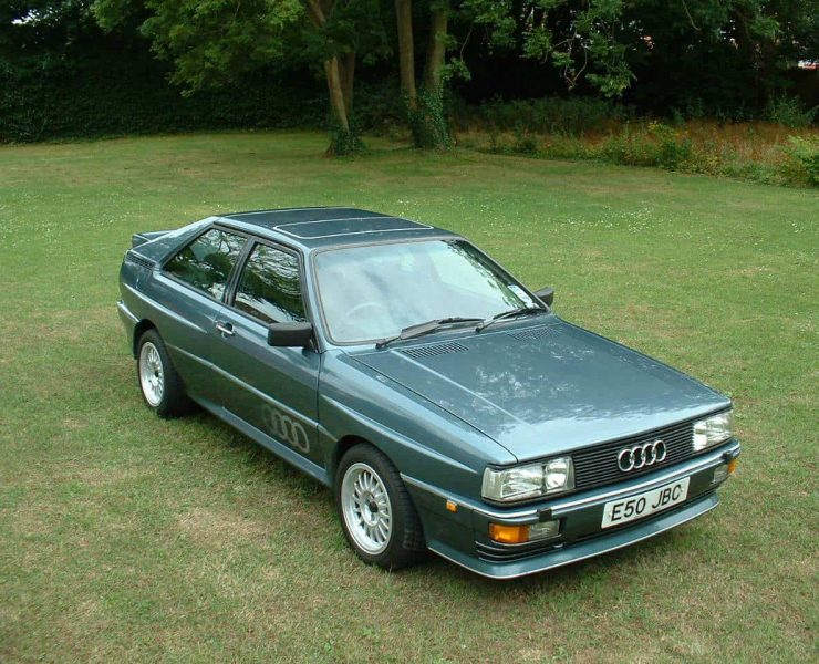 A green Audi Quattro sits on a patch of grass