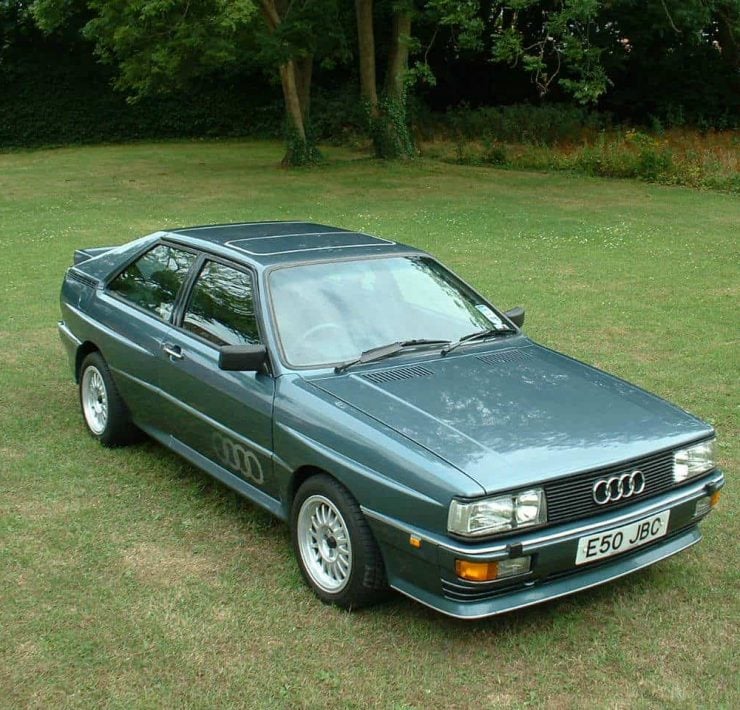 A green Audi Quattro sits on a patch of grass