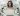 A women working on a laptop sits in a room full of human looking robots made out of shiny plastic