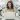 A women working on a laptop sits in a room full of human looking robots made out of shiny plastic