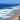 A beautiful beach viewed from a cliff top with sets of waves rolling in