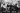 The band Pink Flord sit on a bench in a 70s black and white picture with their hands over their eyes