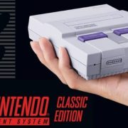 Mini Nintendo SNES classic held in the palm of someones hand
