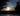 Sunset behind two trees on either side. A canal is seen in the foreground. Picture in article about living as a minimalist