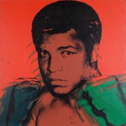 Muhammed Ali as painted by Andy Warhol in 1978. The picture is coloured red with Ali's features black and his fists green