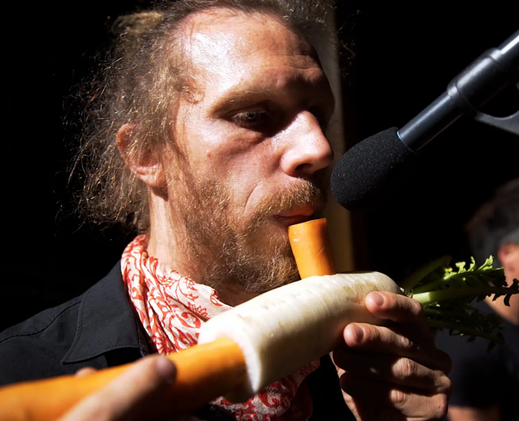 Man from vegetable orchastra 'playing' a carrot