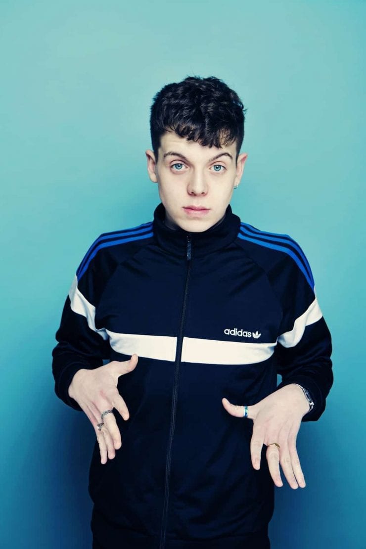 comedian Ed Night poses with hands out in front of his body