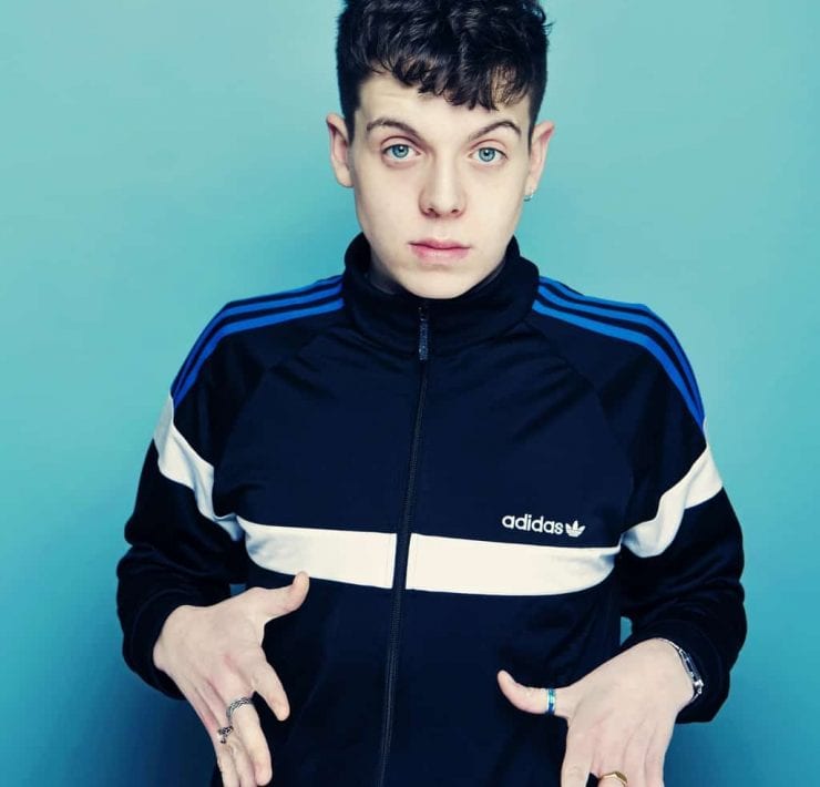 comedian Ed Night poses with hands out in front of his body