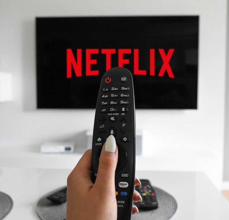 woman pointing remote at netflix