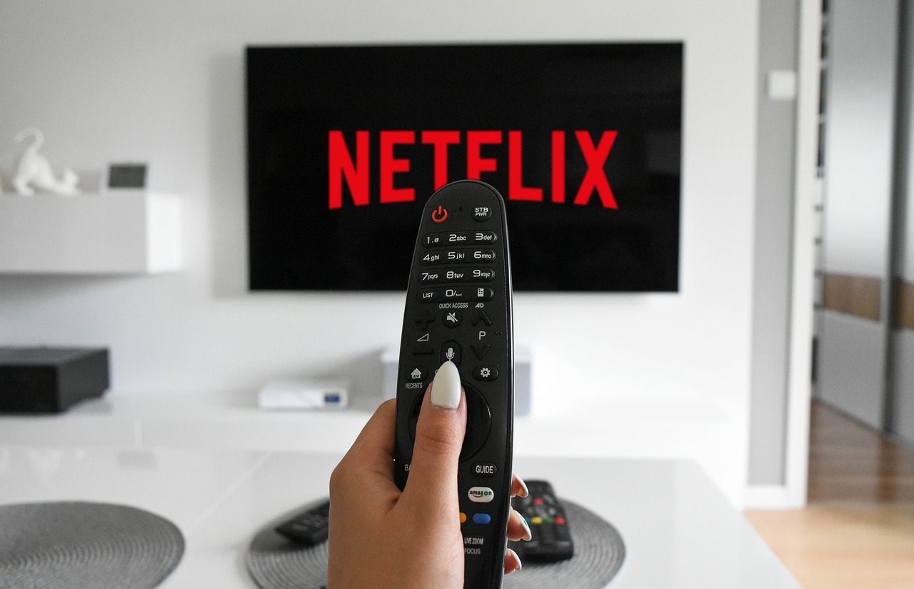 woman pointing remote at netflix