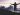 A man at the top of a mountain looking at the clouds