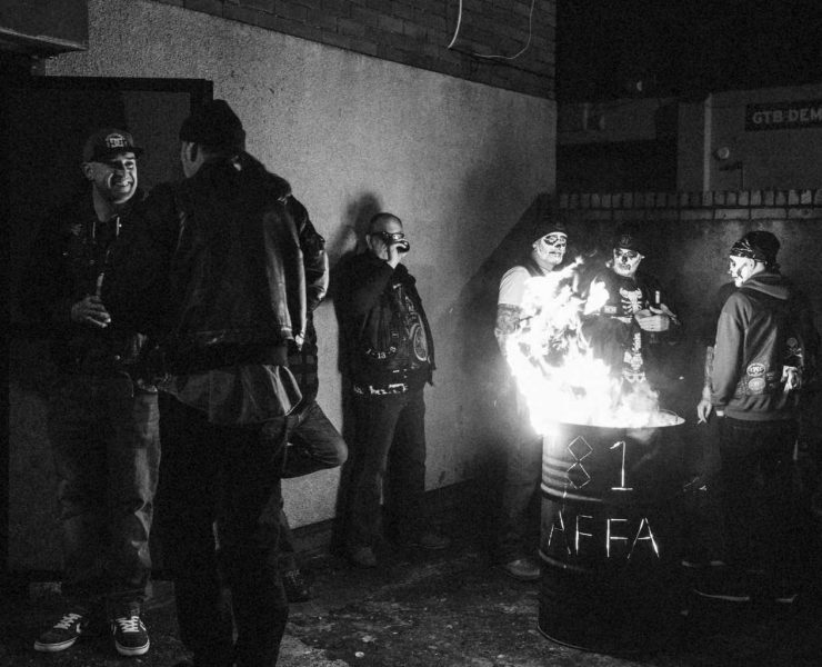 Hell's Angels members standing around a fire in a barrel by photographer Andrew Shaylor