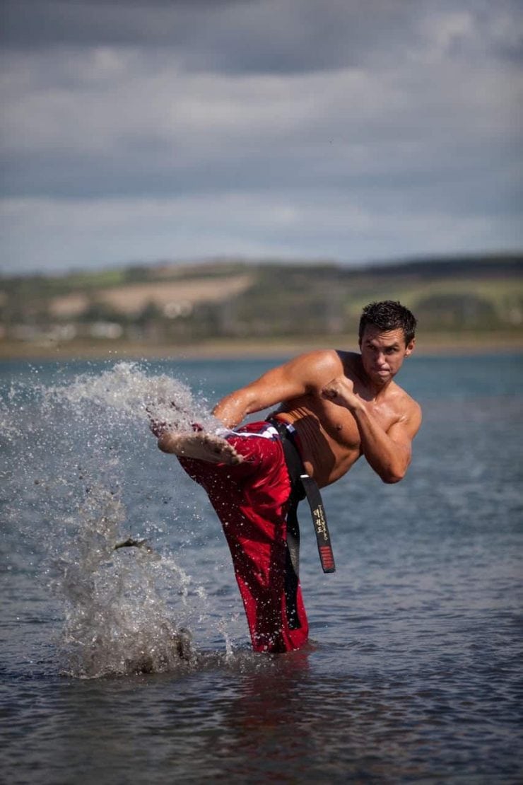 Matt Fiddes performs a karate kick in the sea