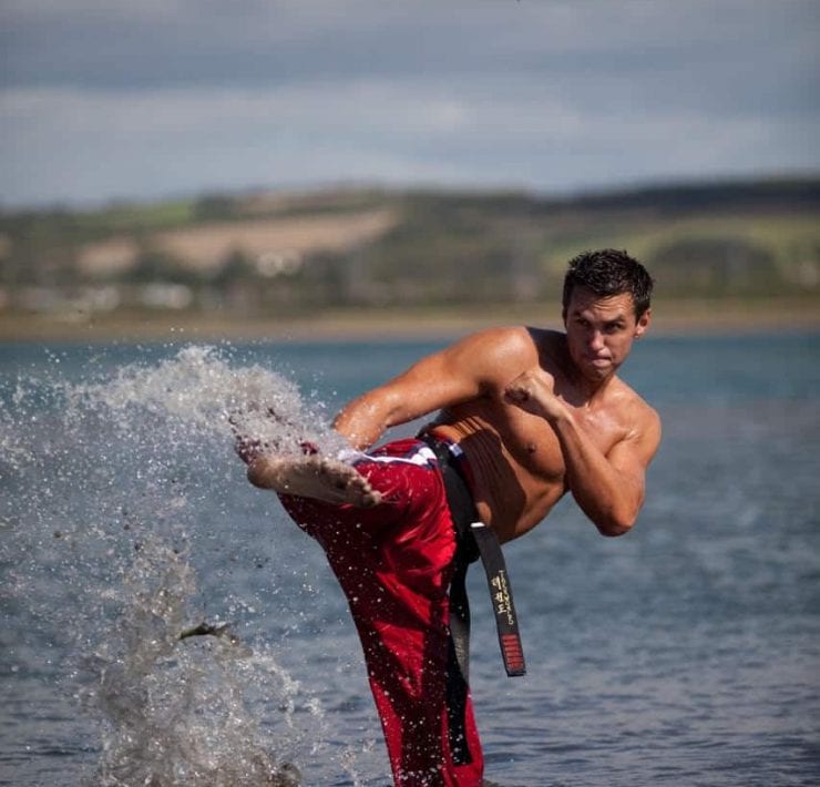 Matt Fiddes performs a karate kick in the sea