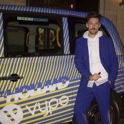 Fashion designer Henry Holland poses next to a London taxi