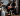 man with face painted in spooky way playing guitar in front of woman