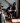 man with face painted in spooky way playing guitar in front of woman