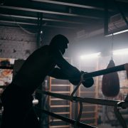 man in a boxing ring holding ropes