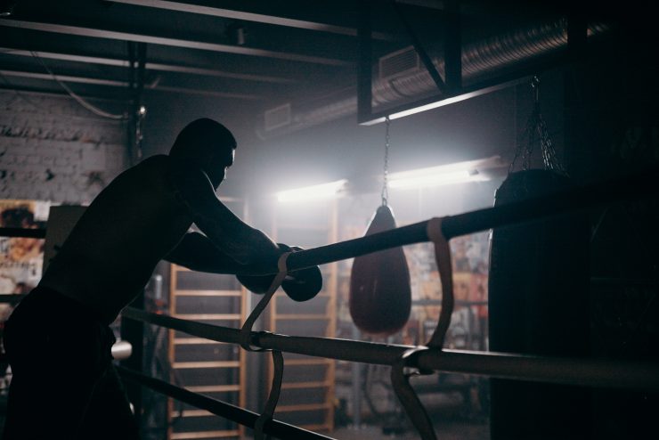 man in a boxing ring holding ropes