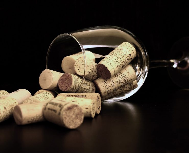 A wine glass on its side filled with corks