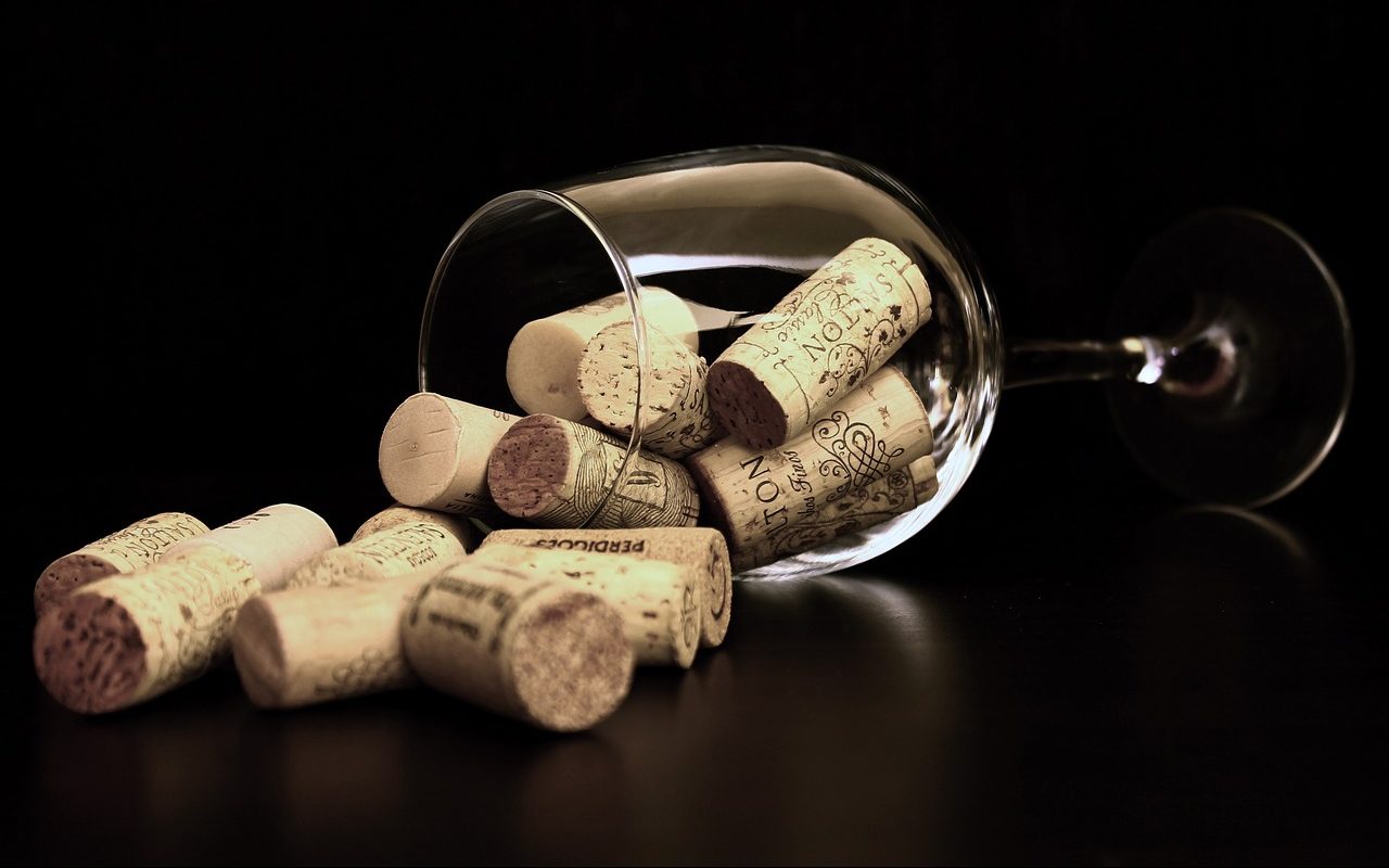 A wine glass on its side filled with corks