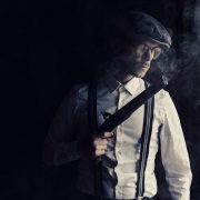 gangster holding a gun in the shadows