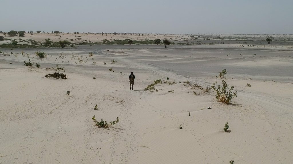 Reza Pakraven walks on bare desert around lake Chad