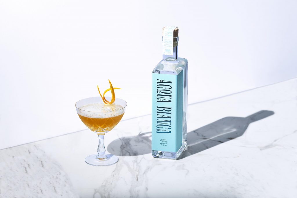 Acqua Bianko bottle next to a cocktail