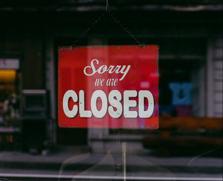 "Sorry We Are Closed" sign hanging in a window