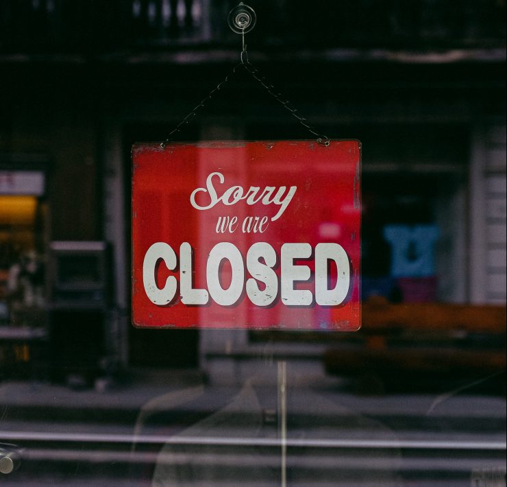 "Sorry We Are Closed" sign hanging in a window