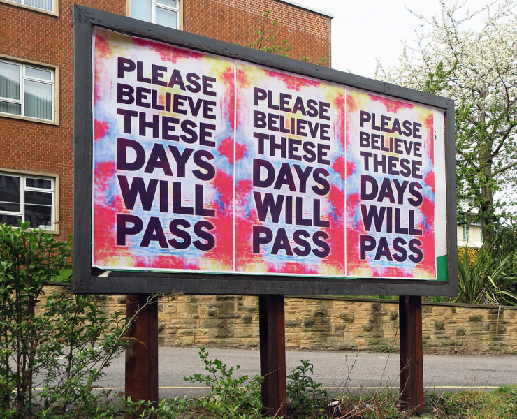 A sign reads 'Please believe these days will pass'