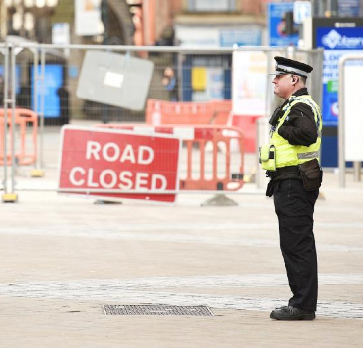 Policeman speaking to a man with a bike during lockdown
