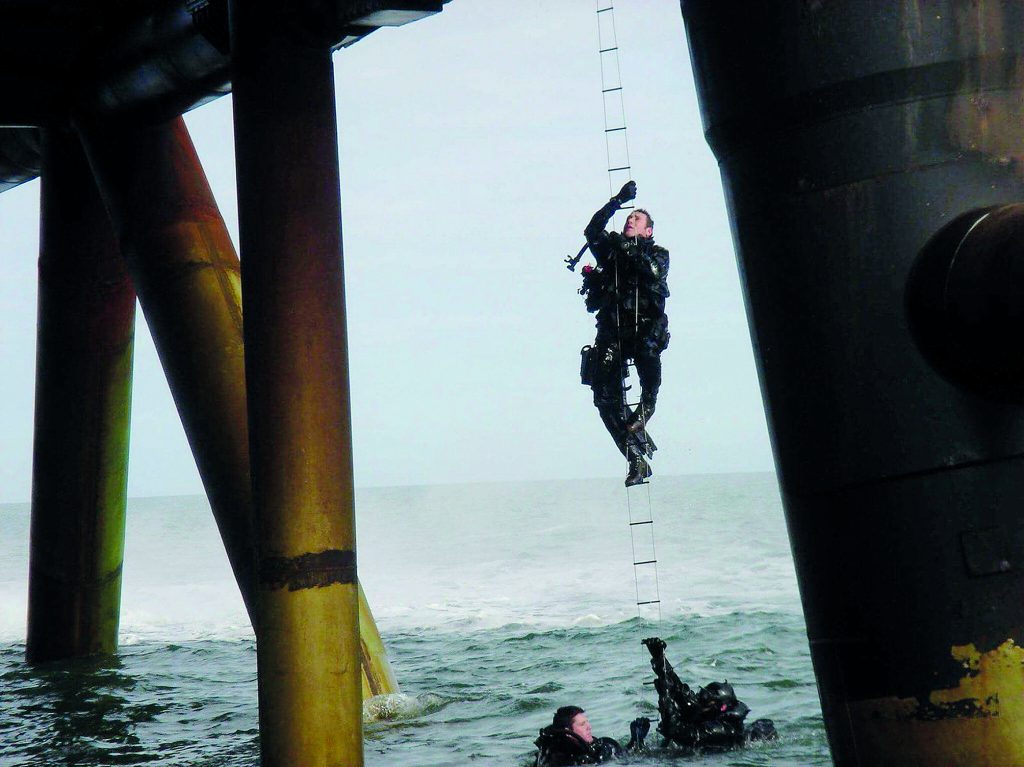 Jason Fox climbing up an oil rig in his SBS days
