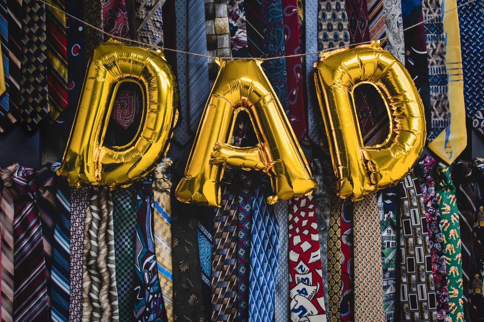 'DAD' written in balloons in front of lots of ties