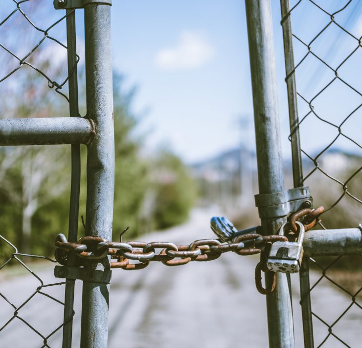Padlocked gate in front of a road