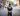 Male policeman standing in the middle of a road with his back to camera