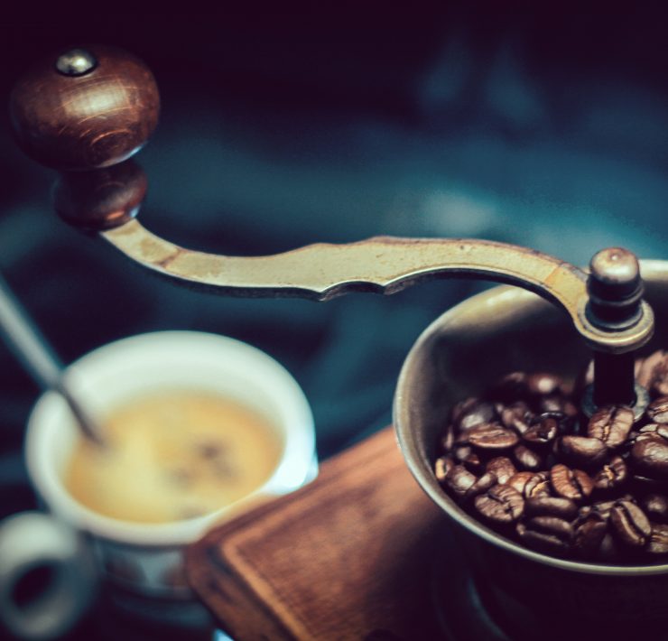 A coffee grinder and a cup of coffee