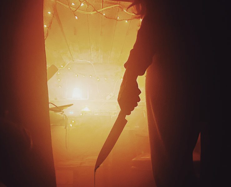 man holding a knife dripping with blood