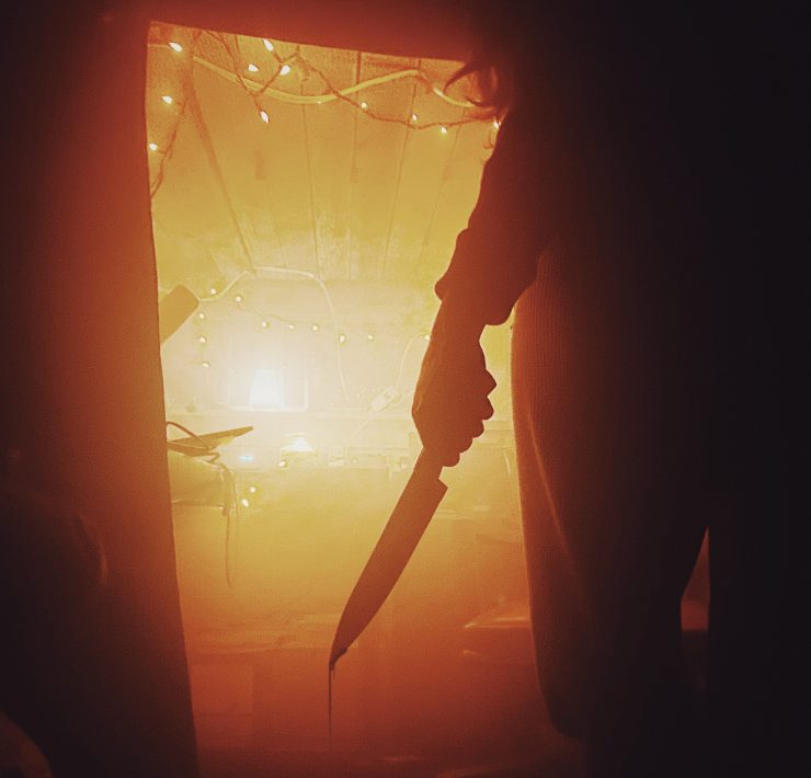 man holding a knife dripping with blood